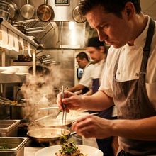 A chef plating in a working kitchen