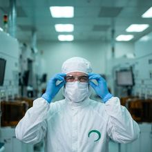 A technician in a cleanroom suit
